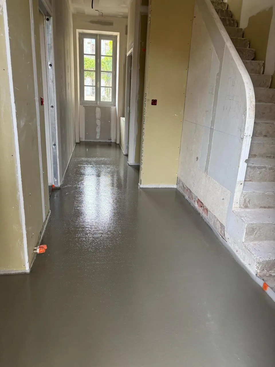 Chape liquide autonivelante en cours de séchage — surface miroir